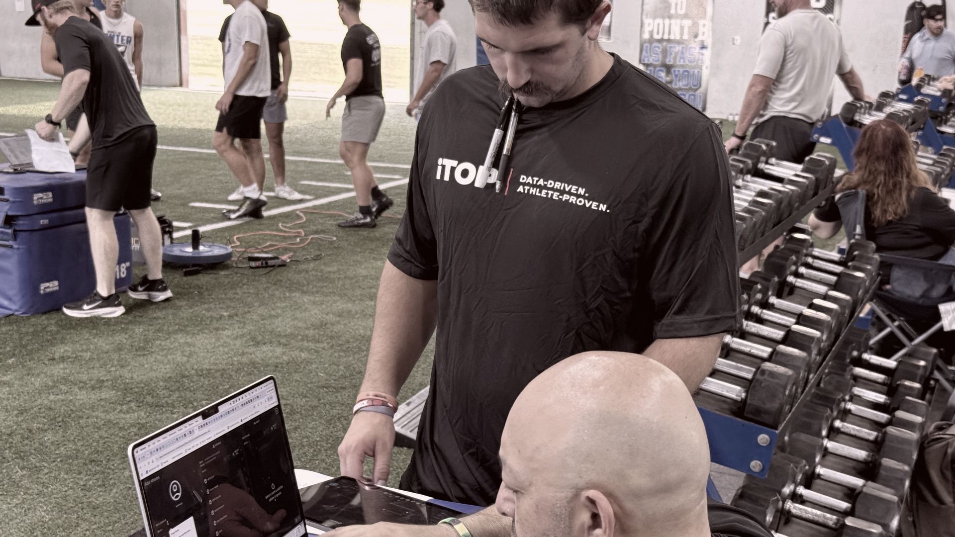 Clinician reviewing live test data on a laptop next to an athlete