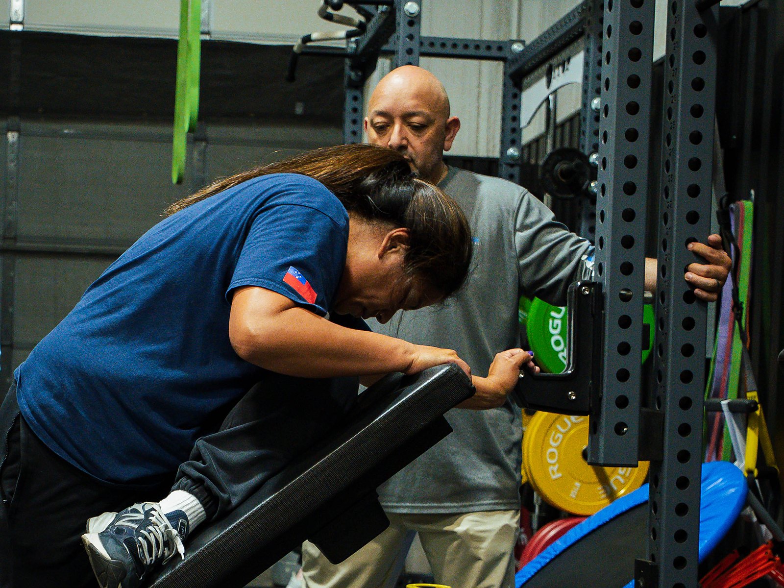 iTOP clinician coaching an athlete through an incline bench exercise in the gym