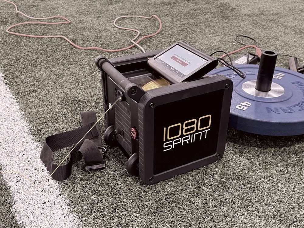 1080 Sprint unit with its touchscreen, harness and cord on turf