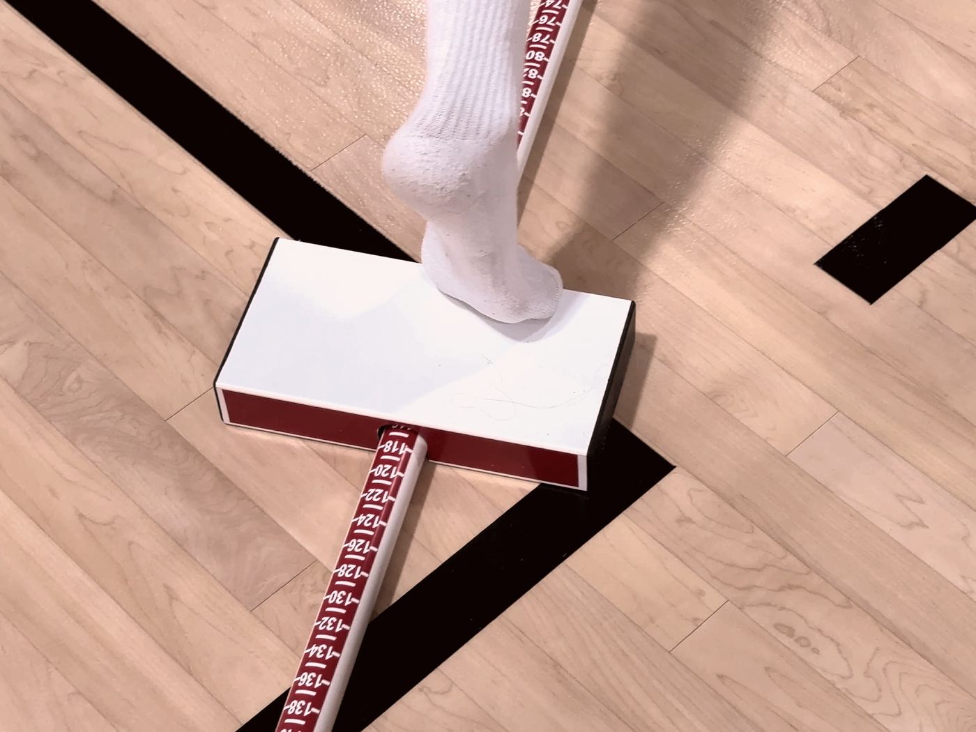 Athlete reaching with one foot on the Y-Balance Test block during clinical return-to-play testing